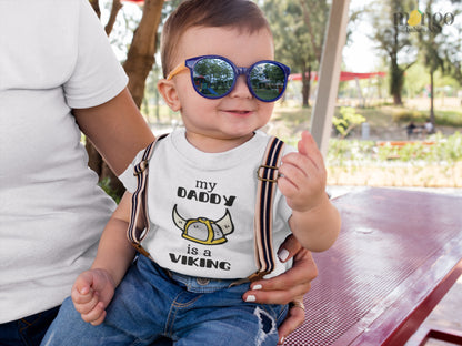 White Tshirt with a printed graphic of the text 'My daddy is a viking.' This playful design celebrates the strong bond between a child and their Viking dad.