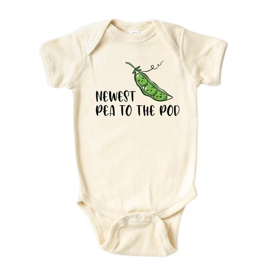 Natural Short Sleeve Baby Bodysuit with a pea icon and the text 'Newest Pea to The Pod.' This adorable design symbolizes the arrival of a new family member, capturing the joy and excitement. Celebrate your little one with this cute and stylish tee.