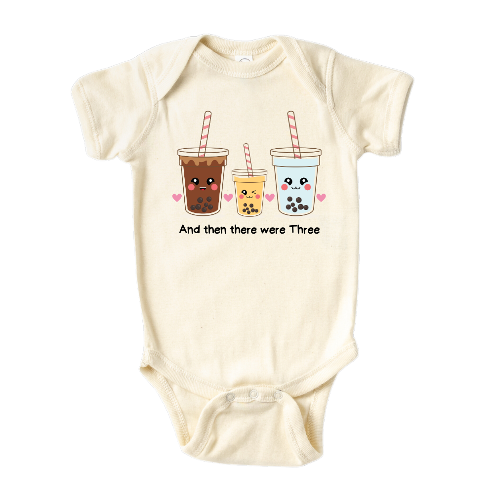Baby bodysuit featuring an endearing printed graphic of a Milk Tea family and the heartwarming text 'And Then There Were Three.' Celebrate the joy of family with this delightful tee, perfect for little ones and proud parents.
