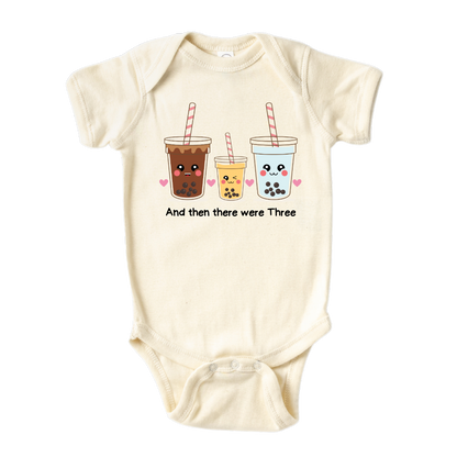 Baby bodysuit featuring an endearing printed graphic of a Milk Tea family and the heartwarming text 'And Then There Were Three.' Celebrate the joy of family with this delightful tee, perfect for little ones and proud parents.