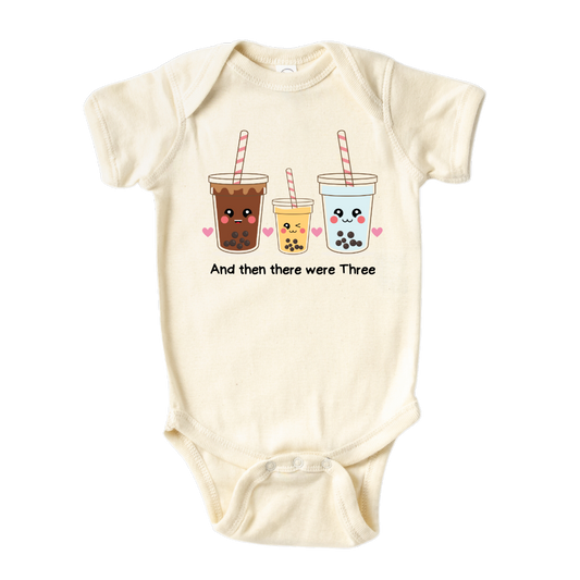 Baby bodysuit featuring an endearing printed graphic of a Milk Tea family and the heartwarming text 'And Then There Were Three.' Celebrate the joy of family with this delightful tee, perfect for little ones and proud parents.