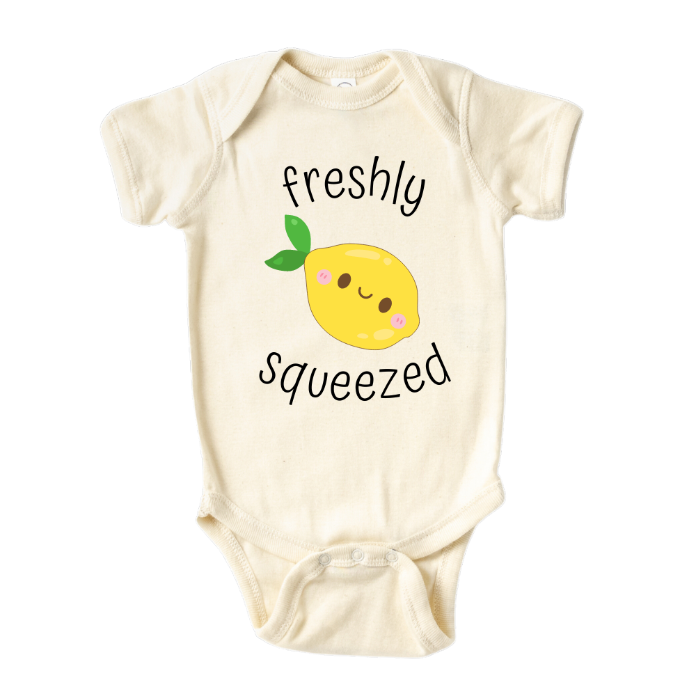 A kids' t-shirt with an adorable graphic of a cute lemon and the text 'Freshly Squeezed.' This design captures the refreshing and playful nature of the citrus fruit, adding a vibrant touch to the wearer's style. It's a delightful and eye-catching tee that stands out with its zestful charm.