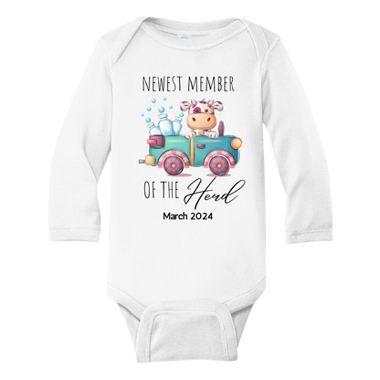 A charming design on a kid's t-shirt and baby onesie featuring a cute cow and milk truck, with the text 'Newest Member of the Herd.' Celebrate the arrival of your little one in style with this adorable outfit!
