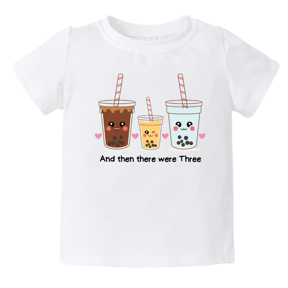 White Tshirt featuring an endearing printed graphic of a Milk Tea family and the heartwarming text 'And Then There Were Three.' Celebrate the joy of family with this delightful tee, perfect for little ones and proud parents.
