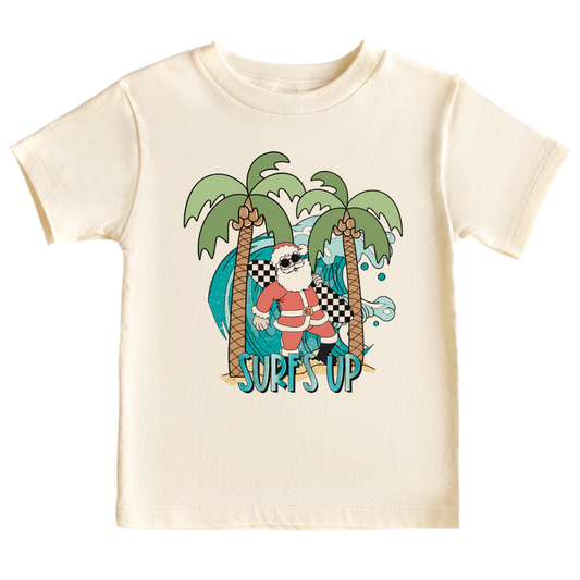 Kids' t-shirt with a funny Santa surfing graphic and the text 'Surf's Up' - perfect for adding some holiday cheer and beach vibes to their outfit.