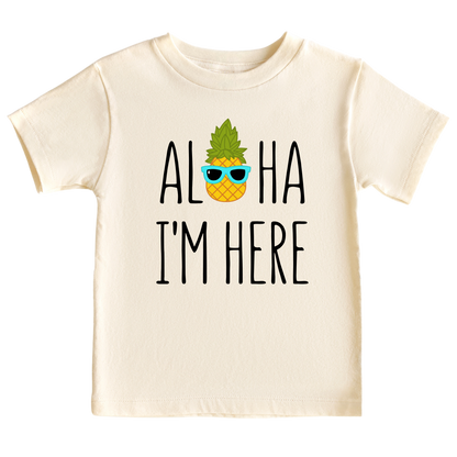 A kids' t-shirt with a pineapple wearing glasses and the text 'Aloha I'm Here.' This fun and tropical design captures the playful spirit, adding a vibrant touch to the wearer's style.