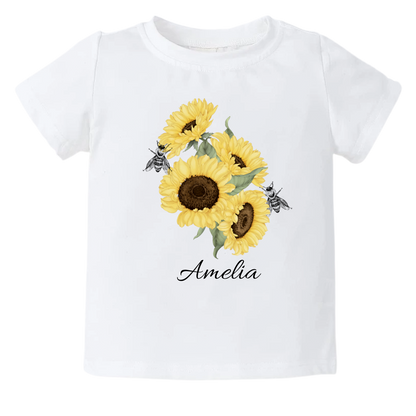 A kid's t-shirt with a cute printed graphic of sunflowers and bees, personalized with a customized name. This delightful tee is stylish, comfortable, and made from high-quality materials. 
