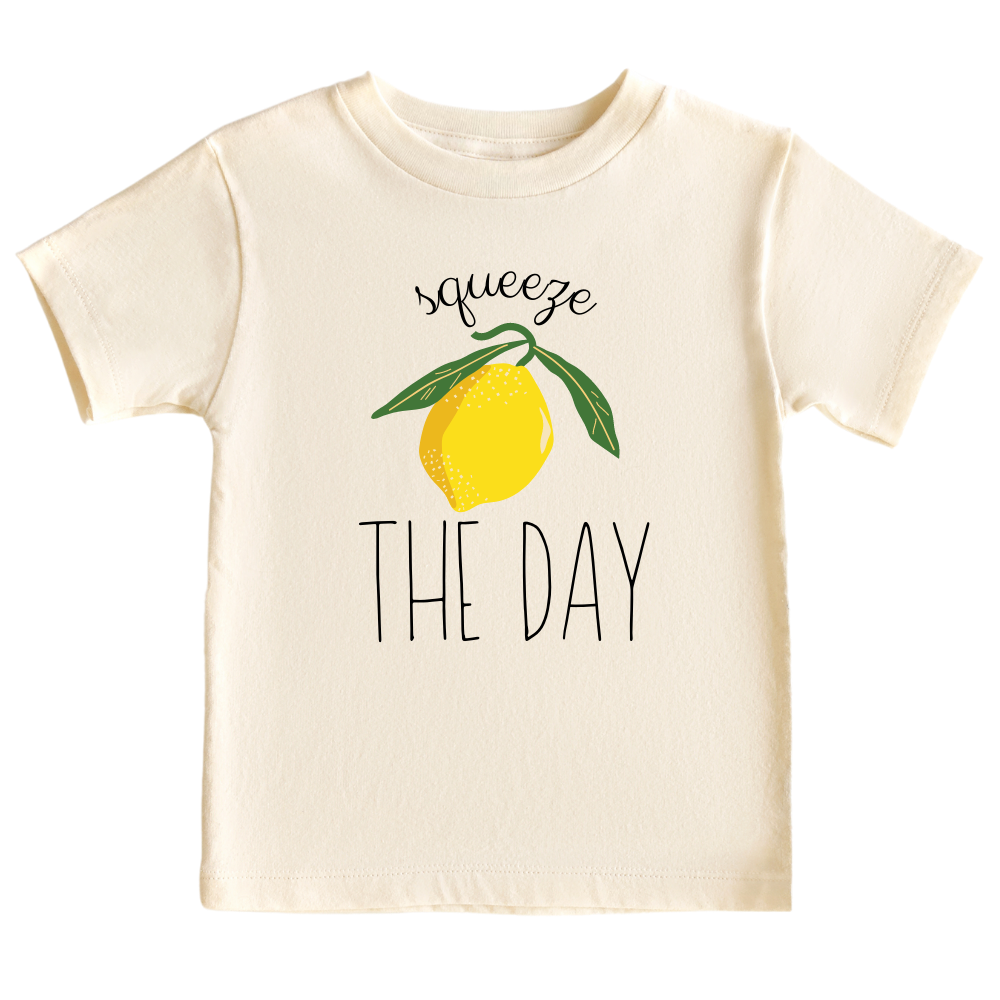 Natural Short Sleeve Kid Tshirt with a cute lemon graphic and the text 'Squeeze The Day.' This vibrant design encourages seizing opportunities and embracing positivity