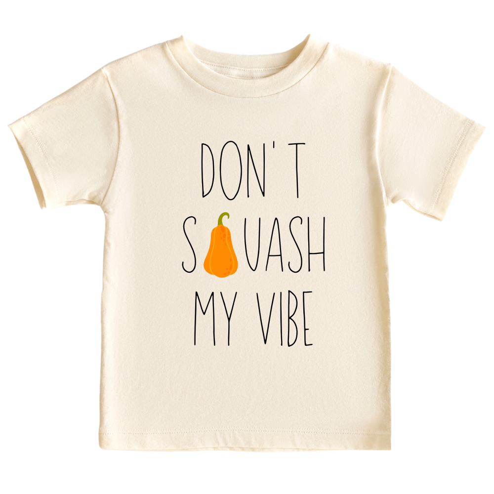 Natural Kid's t-shirt featuring a fall-themed printed graphic of a squash and the fun text 'Don't Squash My Vibe.' Explore this trendy tee, perfect for embracing autumn style. 
